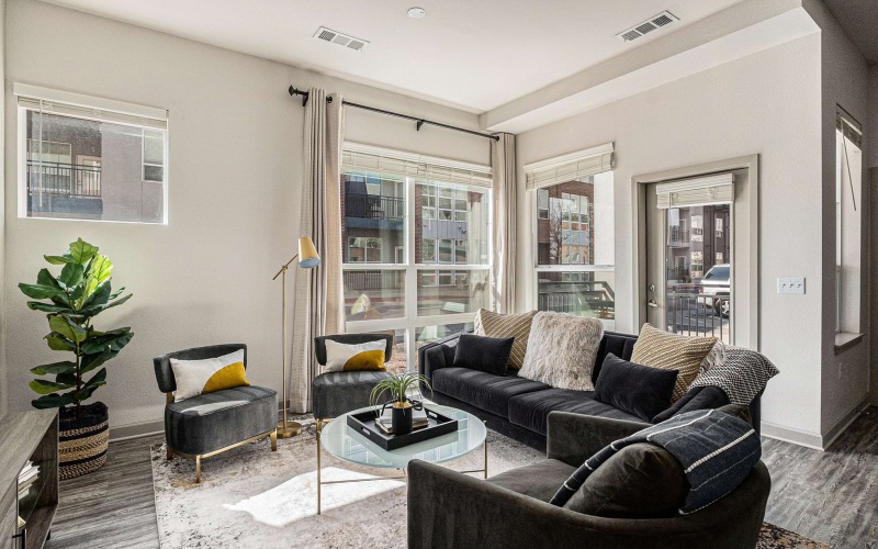 living room with a couch windows and view of a kitchen